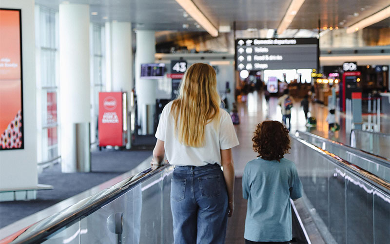 A passenger and child walking through Terminal 1 domestic