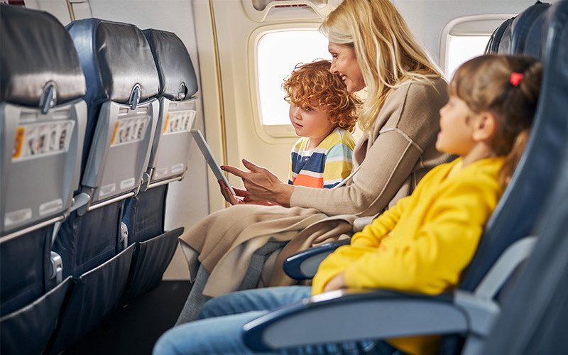 Mother sitting in the middle of two children on a plane