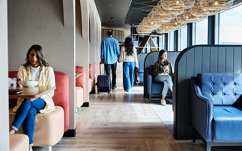 Passengers seated in Perth's Aspire Lounge overlooking the airfield