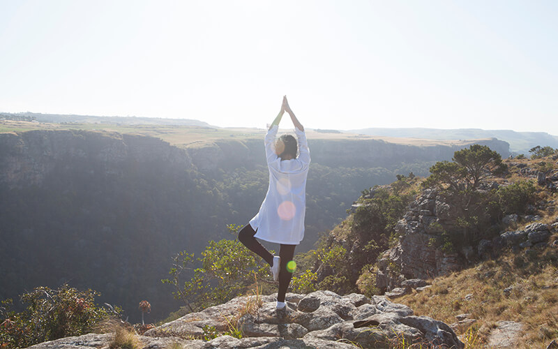 Lady in yoga pose on mountain top