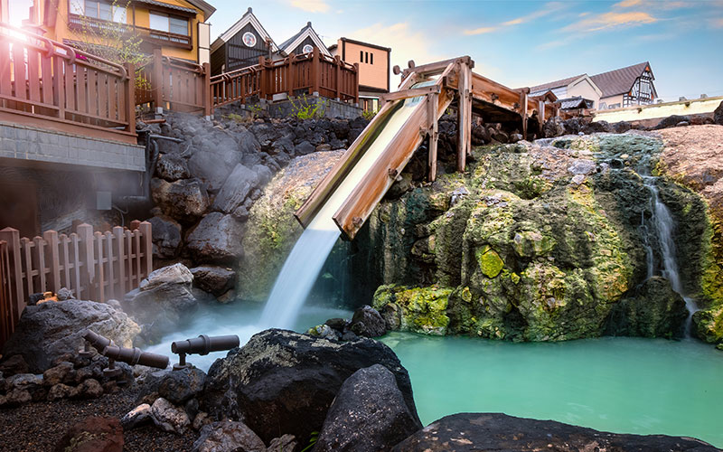 Japanese onsen surrounded by rocks and resort accommodation