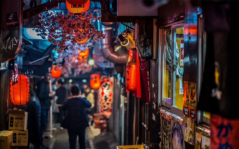 Narrow street in Shinjuku lined with stores and lanterns