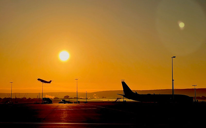 Perth Airport's airfield at sunset with two planes in the background