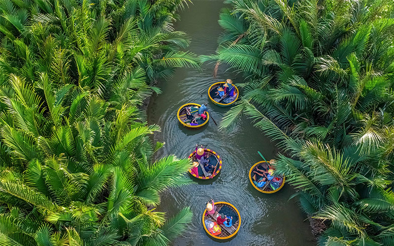 People floating in coconut baskets on a river