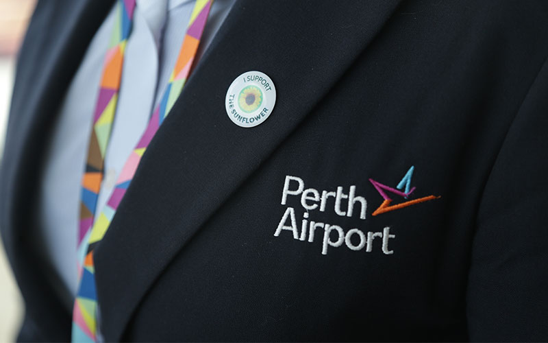 Close up of blazer with Perth Airport logo and a Hidden Disabilities badge